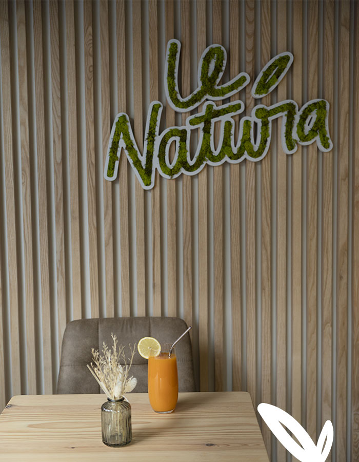 Intérieur du café, logo végétal, jus de fruit et vase de fleurs séchées